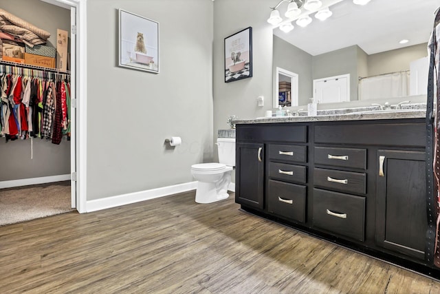 7205 W Grubb Rd NE, Thornville, OH 43076 - bathroom with baseboards, wood finished floors, toilet, and double vanity
