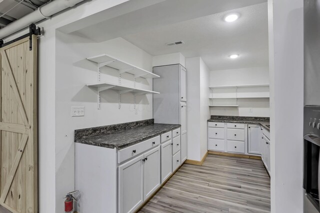 7205 W Grubb Rd NE, Thornville, OH 43076 - kitchen with open shelves, light wood-style flooring, a barn door, white cabinets, and baseboards