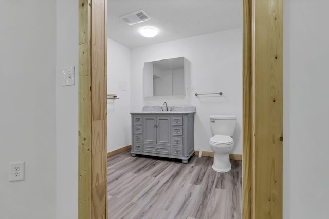 7205 W Grubb Rd NE, Thornville, OH 43076 - bathroom with toilet, wood finished floors, baseboards, and vanity