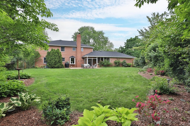 1155 Millcreek Ct, Columbus, OH 43220 - back of house with a chimney, a patio area, a lawn, and a sunroom