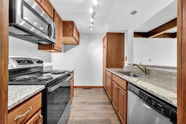 144 W Ticonderoga Dr Unit H, Westerville, OH 43081 - kitchen with appliances with stainless steel finishes, a sink, light wood finished floors, and brown cabinetry