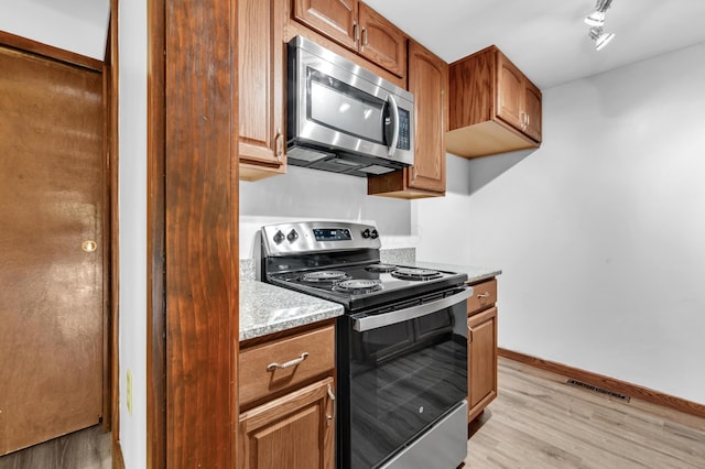 144 W Ticonderoga Dr Unit H, Westerville, OH 43081 - kitchen featuring stainless steel appliances, light wood-style floors, light countertops, and baseboards