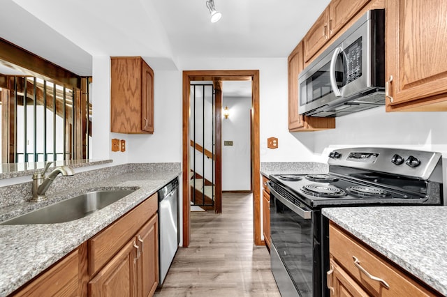 144 W Ticonderoga Dr Unit H, Westerville, OH 43081 - kitchen featuring appliances with stainless steel finishes, a sink, light wood-style floors, and brown cabinetry