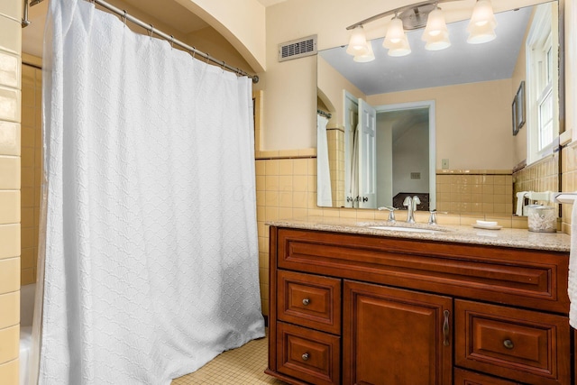 2731 E Broad St, Bexley, OH 43209 - bathroom featuring tile walls, vanity, wainscoting, and tile patterned floors