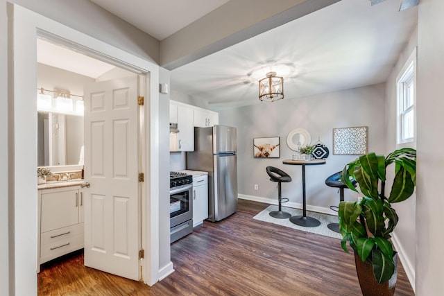 686 Frebis Ave, Columbus, OH 43206 - kitchen featuring appliances with stainless steel finishes, dark wood-style flooring, white cabinetry, light countertops, and a chandelier