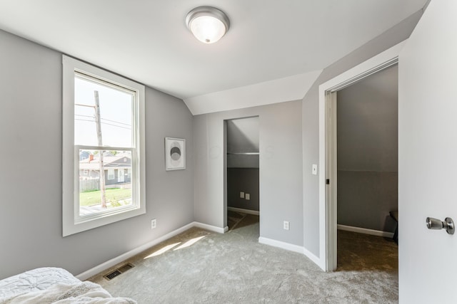 686 Frebis Ave, Columbus, OH 43206 - carpeted bedroom with a walk in closet, lofted ceiling, and baseboards