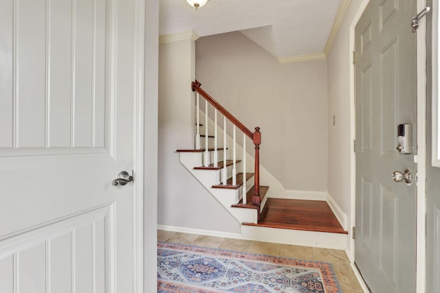 entryway featuring crown molding, baseboards, and stairway