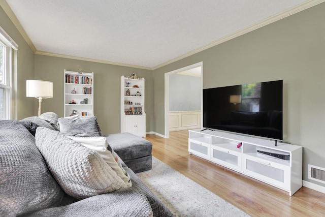 living area with wood finished floors and ornamental molding