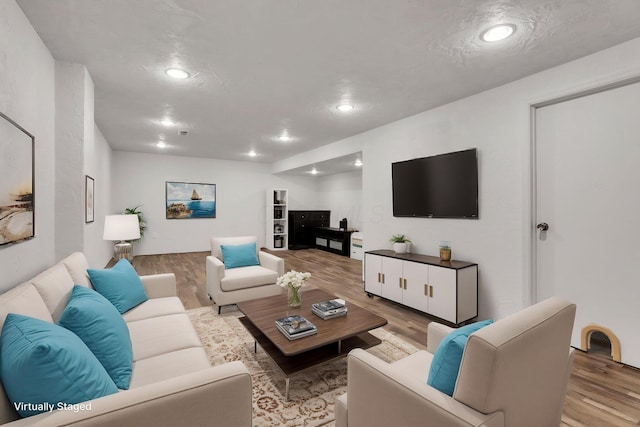 living area with wood finished floors and recessed lighting