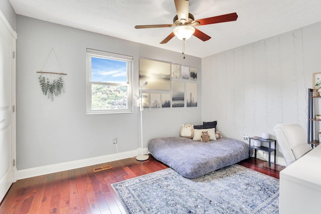 bedroom with hardwood / wood-style floors, baseboards, and a ceiling fan
