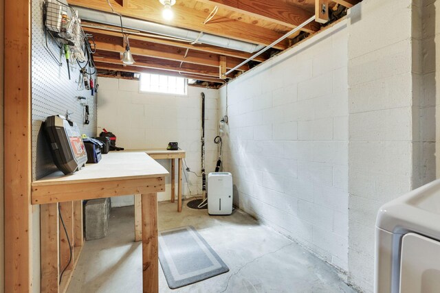 basement with concrete block wall and washer / dryer