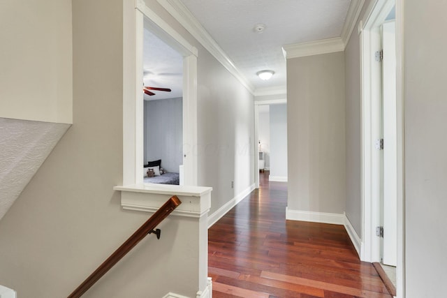 hallway featuring wood finished floors, ornamental molding, baseboards, and an upstairs landing