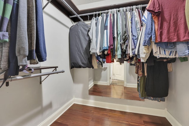 walk in closet with wood finished floors