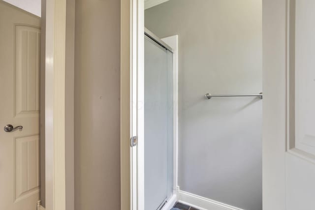 full bathroom featuring a stall shower and baseboards