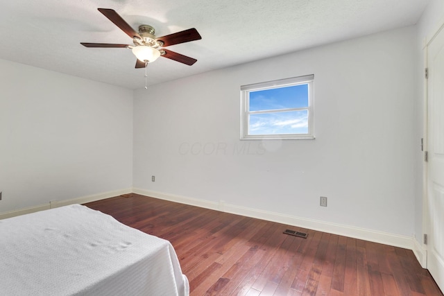 unfurnished bedroom with baseboards, hardwood / wood-style flooring, and ceiling fan