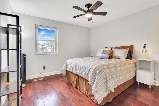bedroom with baseboards, hardwood / wood-style floors, and ceiling fan