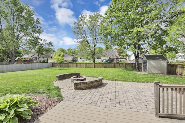 view of patio with an outdoor fire pit, a storage unit, an outbuilding, and a residential view