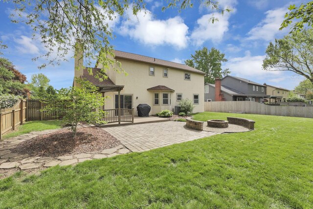 rear view of house with a fire pit, stucco siding, a patio area, and a chimney