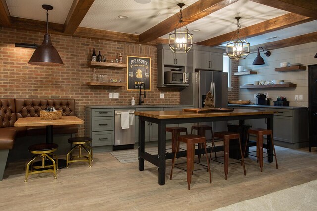 8070 Harriott Rd, Dublin, OH 43017 - bar with stainless steel appliances, light wood finished floors, beam ceiling, a chandelier, and a sink