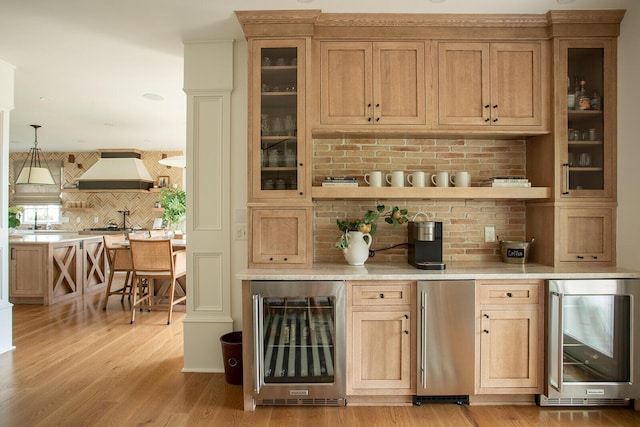8070 Harriott Rd, Dublin, OH 43017 - bar area featuring wine cooler, custom range hood, tasteful backsplash, and light wood-style floors