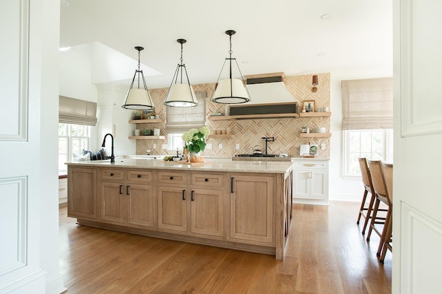8070 Harriott Rd, Dublin, OH 43017 - kitchen featuring open shelves, an island with sink, tasteful backsplash, and light wood-style flooring