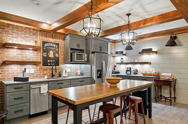 8070 Harriott Rd, Dublin, OH 43017 - kitchen with stainless steel appliances, open shelves, light wood-style floors, gray cabinets, and beamed ceiling