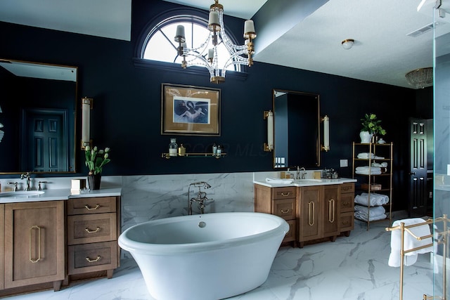 8070 Harriott Rd, Dublin, OH 43017 - full bathroom with marble look tiles, a soaking tub, two vanities, a wainscoted wall, and a chandelier