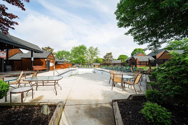 view of patio with fence and a community pool