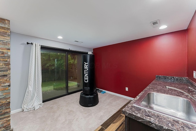 kitchen featuring carpet floors, a sink, dark countertops, baseboards, and recessed lighting