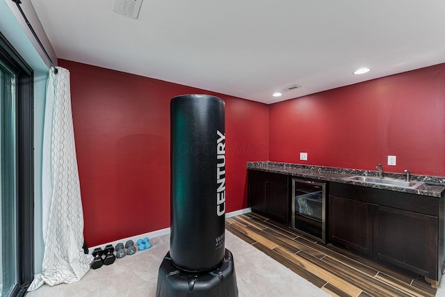 indoor wet bar with wine cooler, wood tiled floors, recessed lighting, and baseboards
