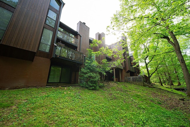 view of green lawn with a balcony