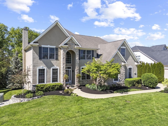 2557 Coltsbridge Dr, Lewis Center, OH 43035 - view of front of property with stone siding, a chimney, stucco siding, and a front yard