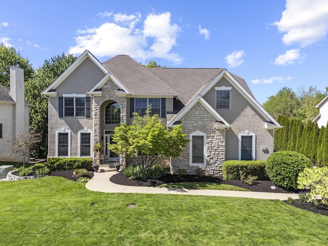 2557 Coltsbridge Dr, Lewis Center, OH 43035 - view of front of house featuring stone siding, a front lawn, and stucco siding