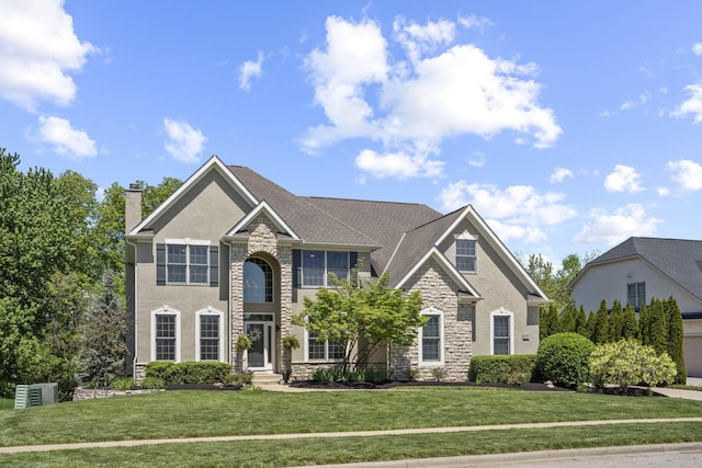2557 Coltsbridge Dr, Lewis Center, OH 43035 - view of front of home featuring stone siding, a front yard, a chimney, and stucco siding