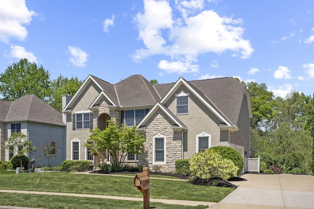 2557 Coltsbridge Dr, Lewis Center, OH 43035 - view of front facade with stone siding, a front lawn, stucco siding, and driveway