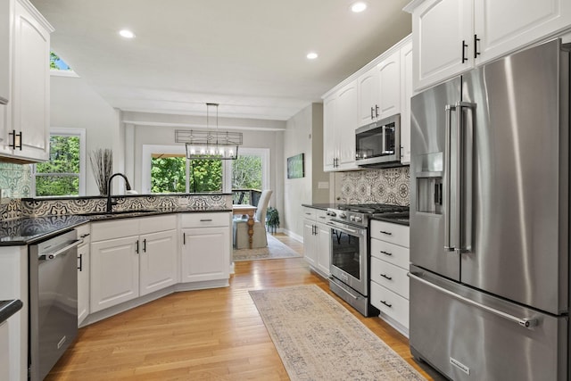 2557 Coltsbridge Dr, Lewis Center, OH 43035 - kitchen with appliances with stainless steel finishes, a sink, white cabinetry, light wood-style floors, and tasteful backsplash
