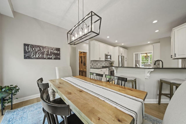 2557 Coltsbridge Dr, Lewis Center, OH 43035 - dining room featuring light wood finished floors, baseboards, recessed lighting, and a chandelier