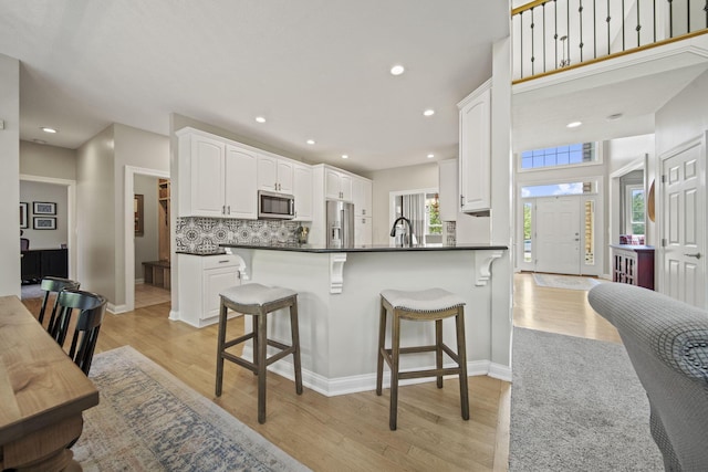 2557 Coltsbridge Dr, Lewis Center, OH 43035 - kitchen featuring appliances with stainless steel finishes, dark countertops, a sink, a kitchen bar, and white cabinets