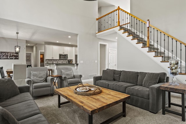 2557 Coltsbridge Dr, Lewis Center, OH 43035 - living area with carpet flooring, a high ceiling, recessed lighting, stairs, and baseboards