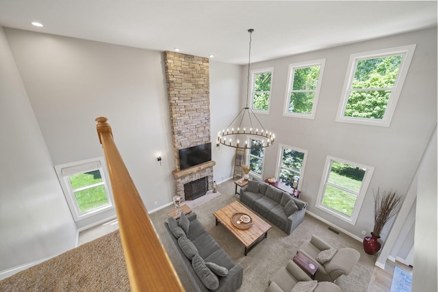 2557 Coltsbridge Dr, Lewis Center, OH 43035 - living area featuring healthy amount of natural light, a fireplace, a chandelier, a high ceiling, and baseboards