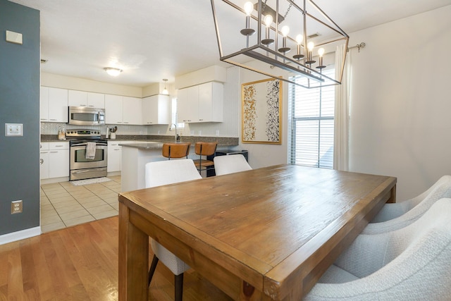 dining area with light wood-style flooring and a chandelier