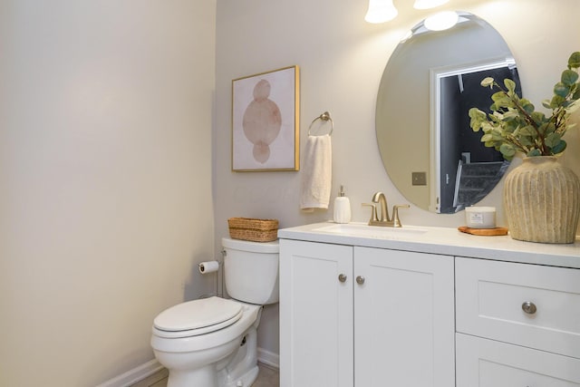 bathroom featuring toilet, vanity, and baseboards