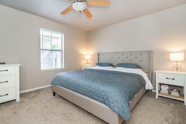 bedroom featuring light carpet, baseboards, and a ceiling fan