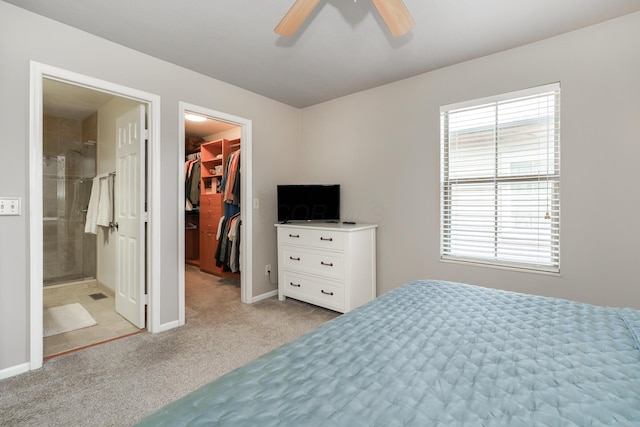 bedroom featuring a walk in closet, multiple windows, light carpet, and a closet