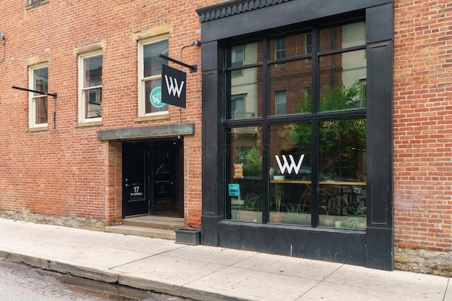 view of exterior entry featuring brick siding