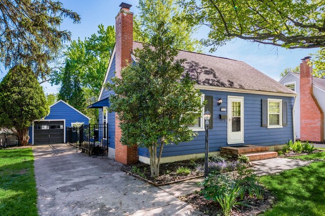 263 E Beaumont Rd, Columbus, OH 43214 - view of front of home with concrete driveway, an outbuilding, a detached garage, and a chimney