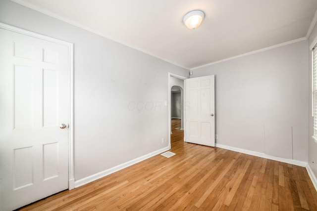 263 E Beaumont Rd, Columbus, OH 43214 - empty room featuring light wood finished floors, ornamental molding, arched walkways, and baseboards