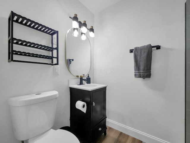 4838 Calvin Dr, Columbus, OH 43227 - bathroom featuring wood finished floors, toilet, baseboards, and vanity