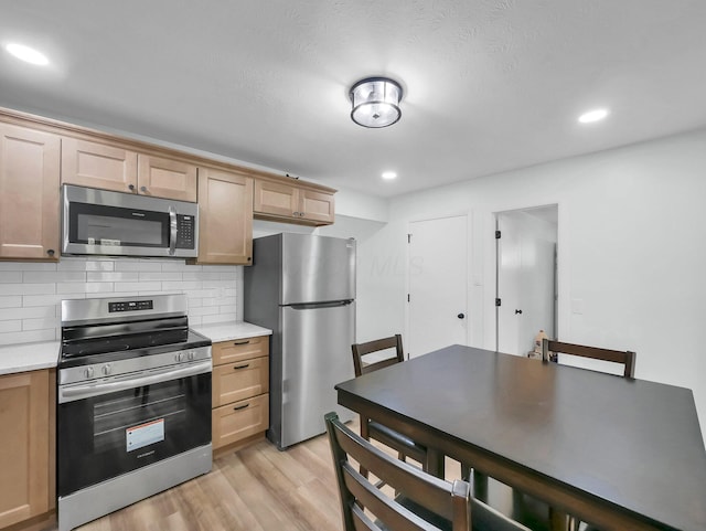 4838 Calvin Dr, Columbus, OH 43227 - kitchen with appliances with stainless steel finishes, light countertops, light wood-style flooring, decorative backsplash, and recessed lighting