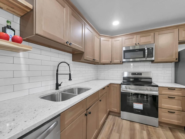 4838 Calvin Dr, Columbus, OH 43227 - kitchen featuring stainless steel appliances, a sink, decorative backsplash, and light stone countertops